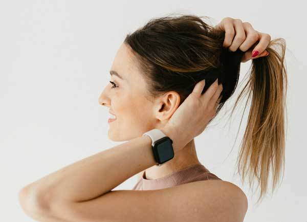 woman adjusting her ponytail before a yoga session