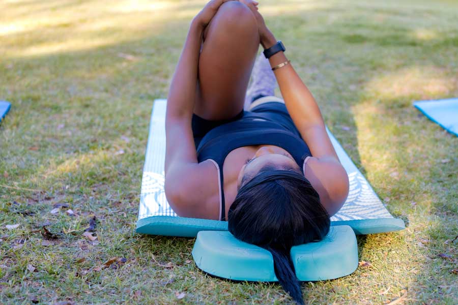 woman practicing stretching and using a pillow for ponytail