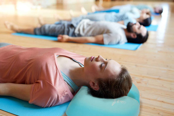 Group of people meditating and using the Ponytail Pillow to avoid distractions and improve comfort