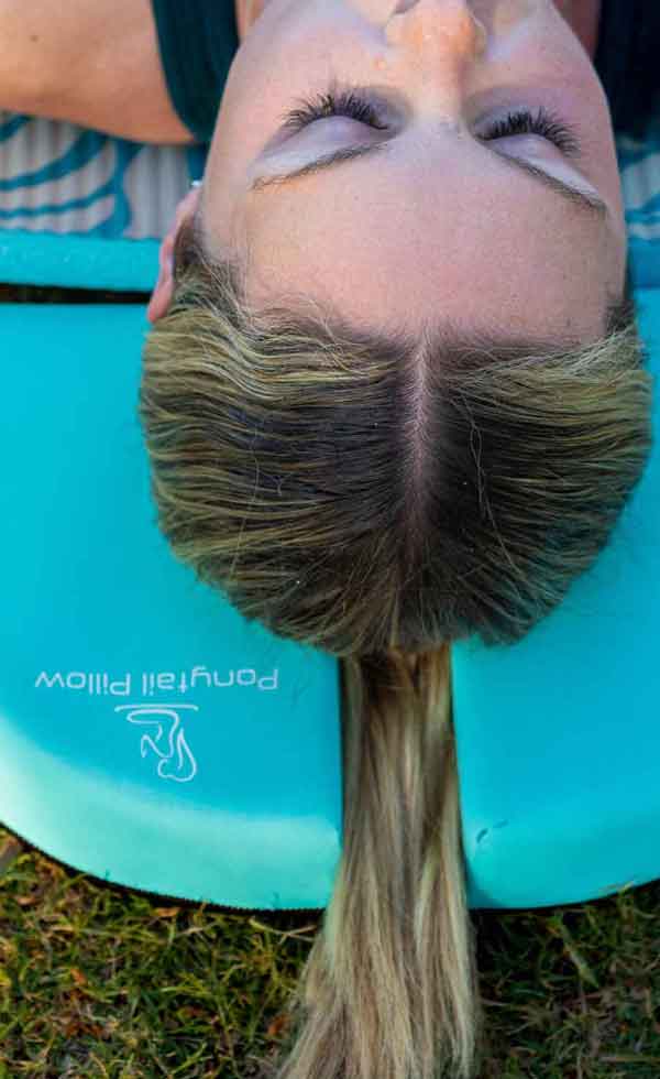 Young woman using a Ponytail Pillow during a Yoga session